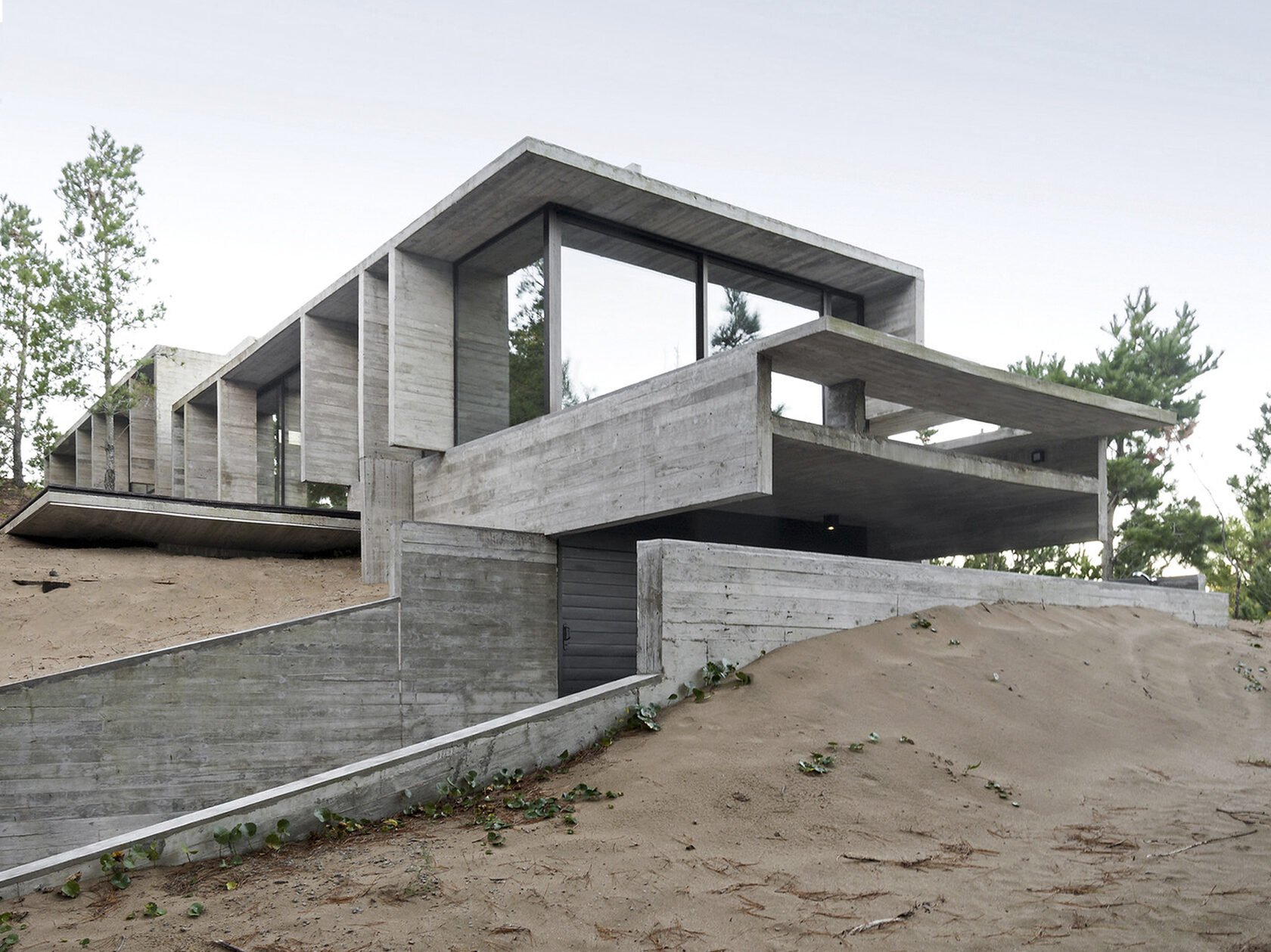 Поселок бетонный. Монолитный бетонный дом. Современный монолитный дом. Современный дом на склоне. Здание из бетона.