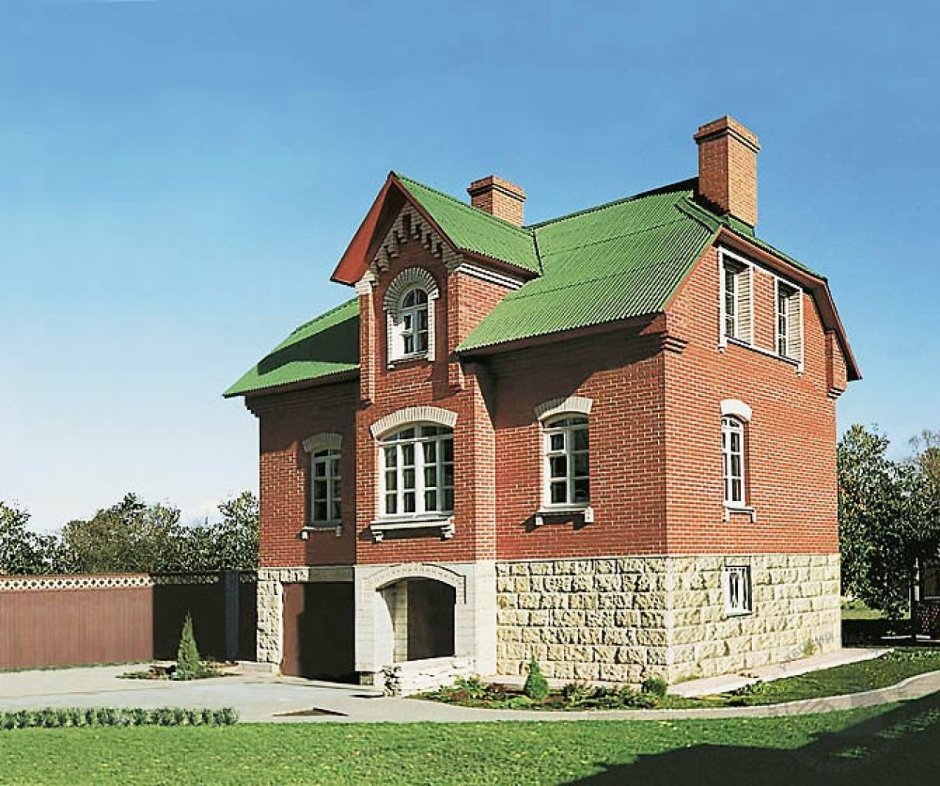 Красный кирпичный дом с зеленой крышей