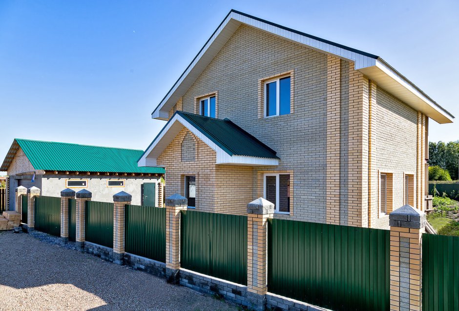Кирпичный дом с забором