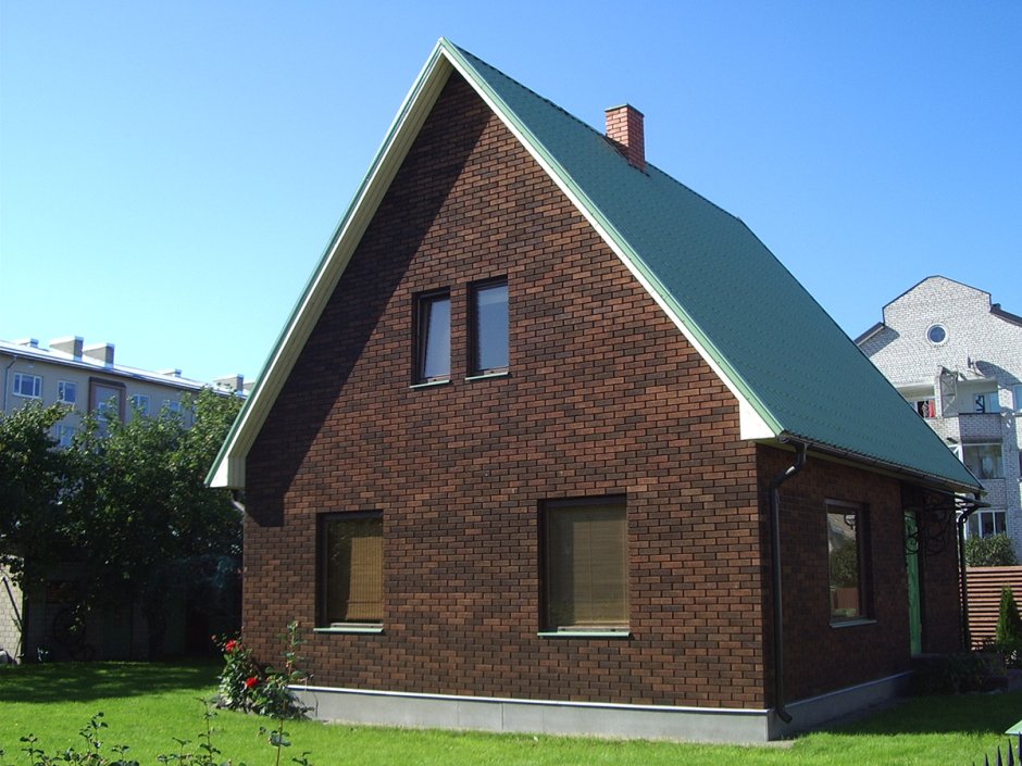 Кирпичный дом с зеленой крышей