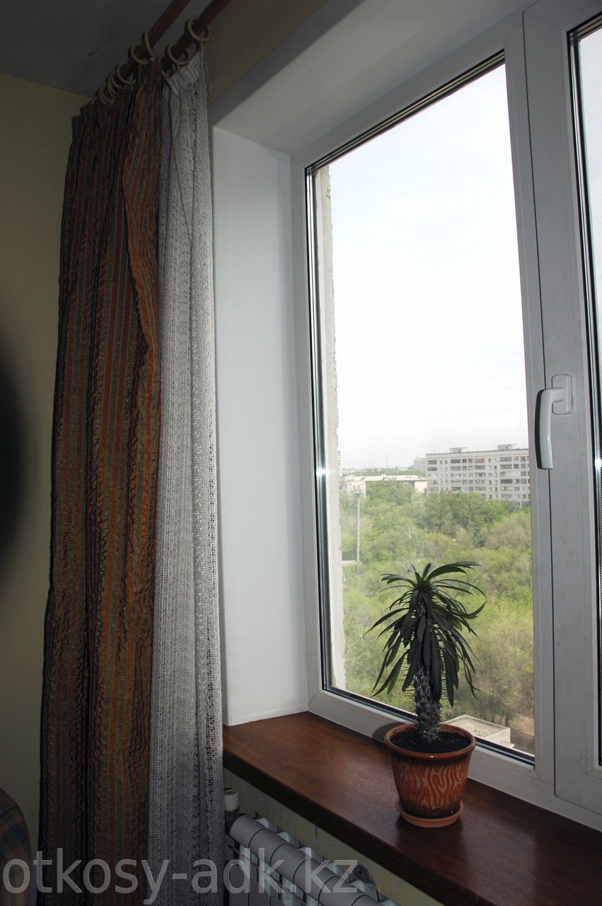 Пластиковое окно с коричневым подоконником